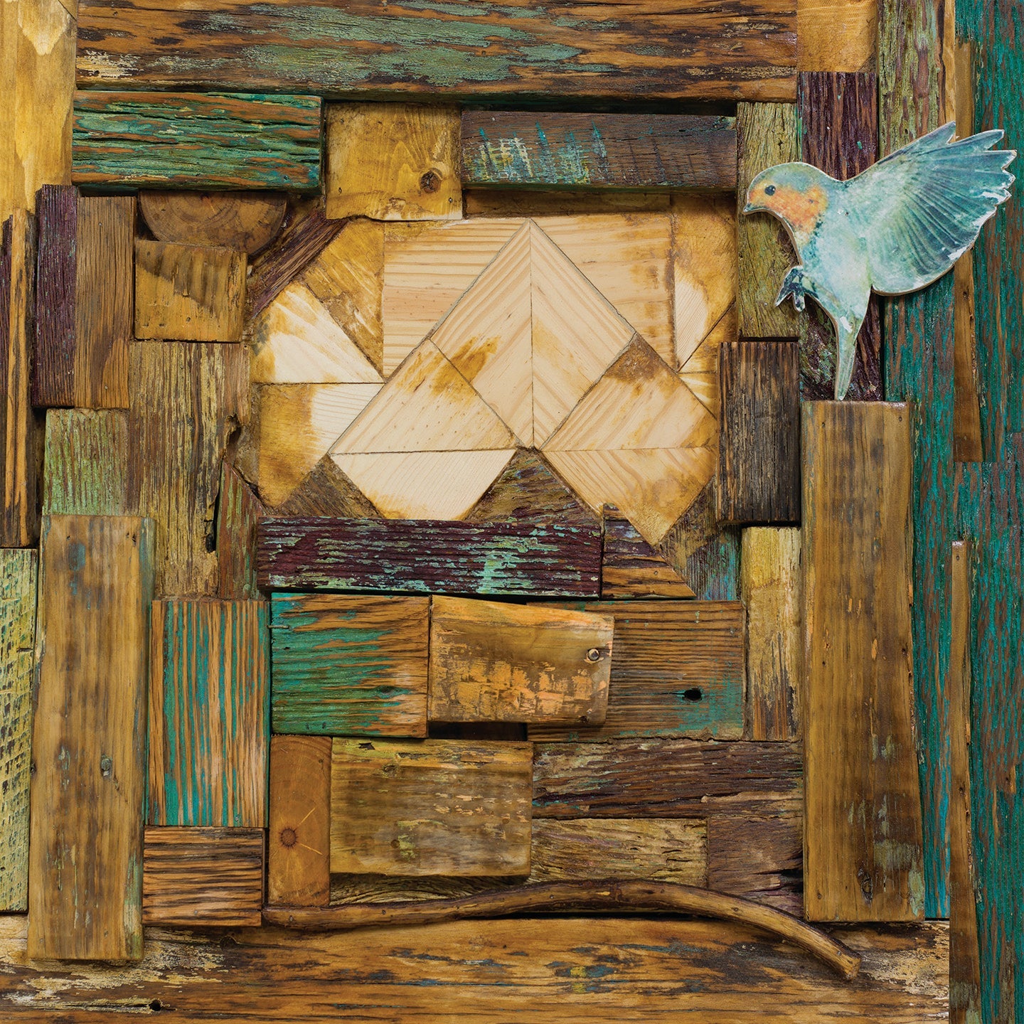 Rustic mixed media artwork with reclaimed wood, greens, and golds framing a bird in mid-flight, evoking warmth and natural texture.